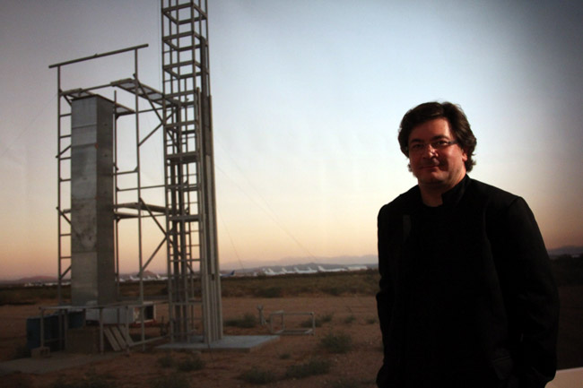 A man stands in front of a launch site in the desert