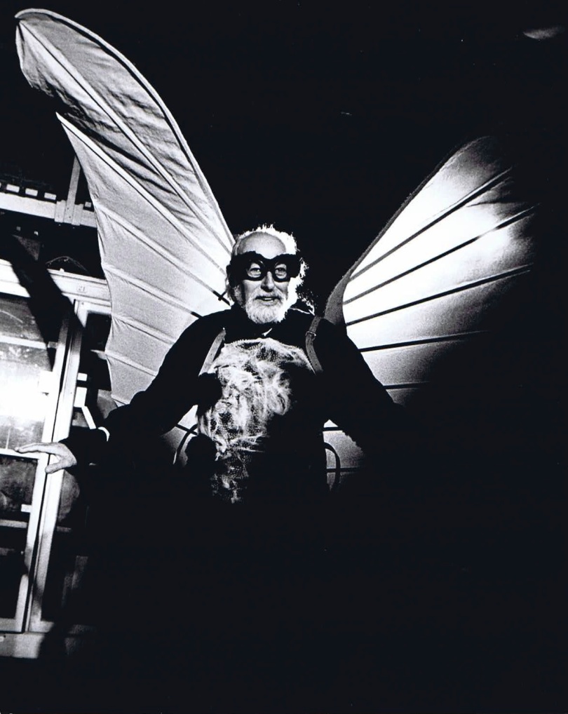 B&W photo. Man dressed as giant butterfly